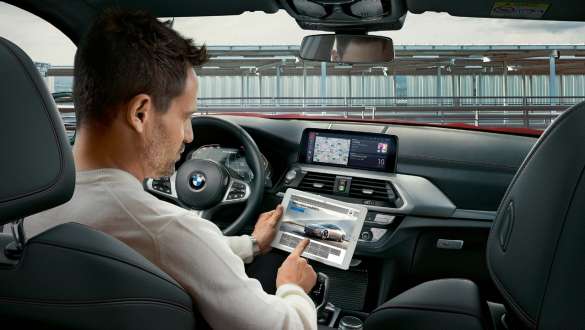 BMW Connected. BMW X4 M Automobiles, BMW Connected, woman holding an illuminated globe.