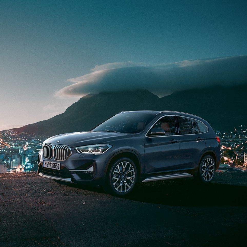 BMW X1, three-quarter side view. BMW X1, three-quarter side view standing in front of urban scenery.
