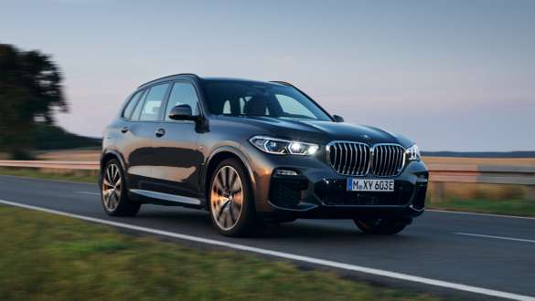 Plug-in hybrid BMW X5 xDrive45e G05 three-quarter front view driving Plug-in hybrid BMW X5 xDrive45e G05 three-quarter front view driving on the street