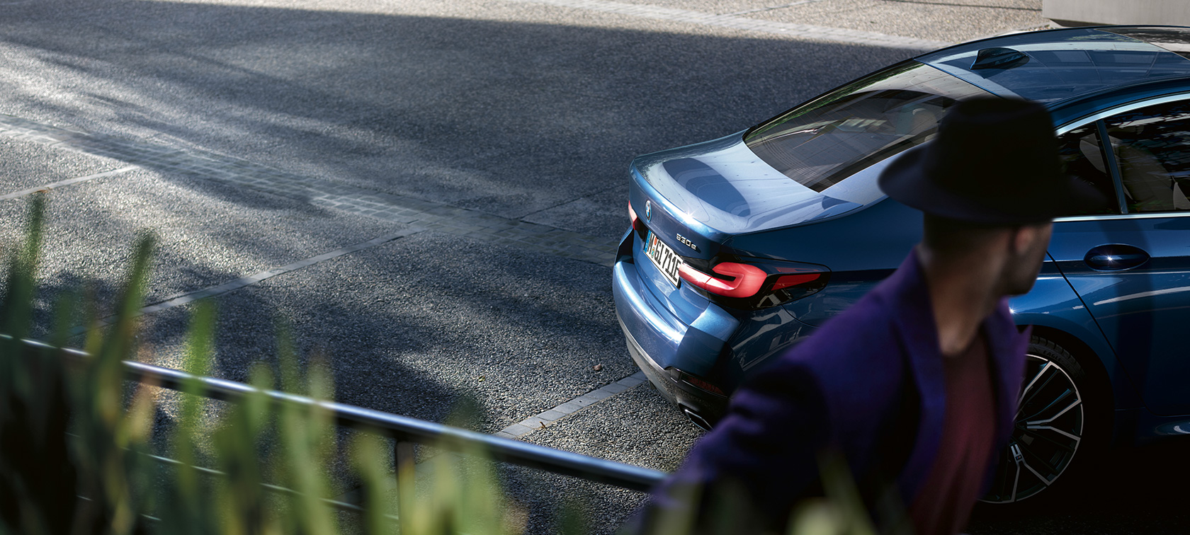 Man standing behind parking BMW BMW 5 Series Sedan G30 BMW 5 Series Sedan G30 Facelift 2020 man standing behind parking BMW