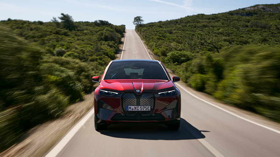 BMW iX i20 electric SUV range BMW iX i20 2021 electric SUV Aventurin Red driving on a street range