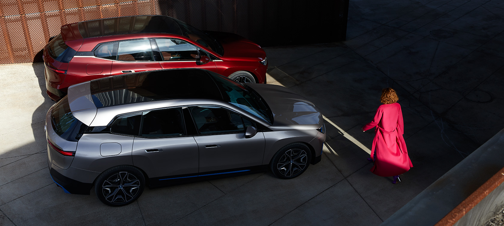 BMW iX bird’s-eye view with model BMW iX Aventurin Red and Cashmere Silver i20 bird’s-eye view with model