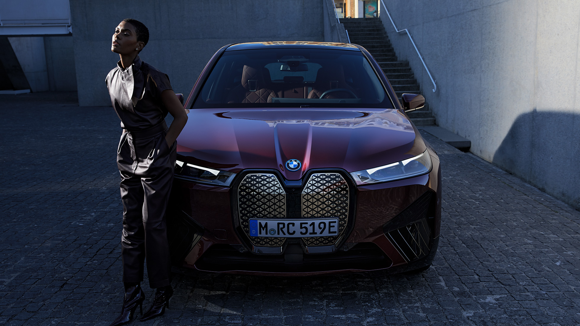 BMW iX front view with model BMW iX Aventurin Red i20 front view with model