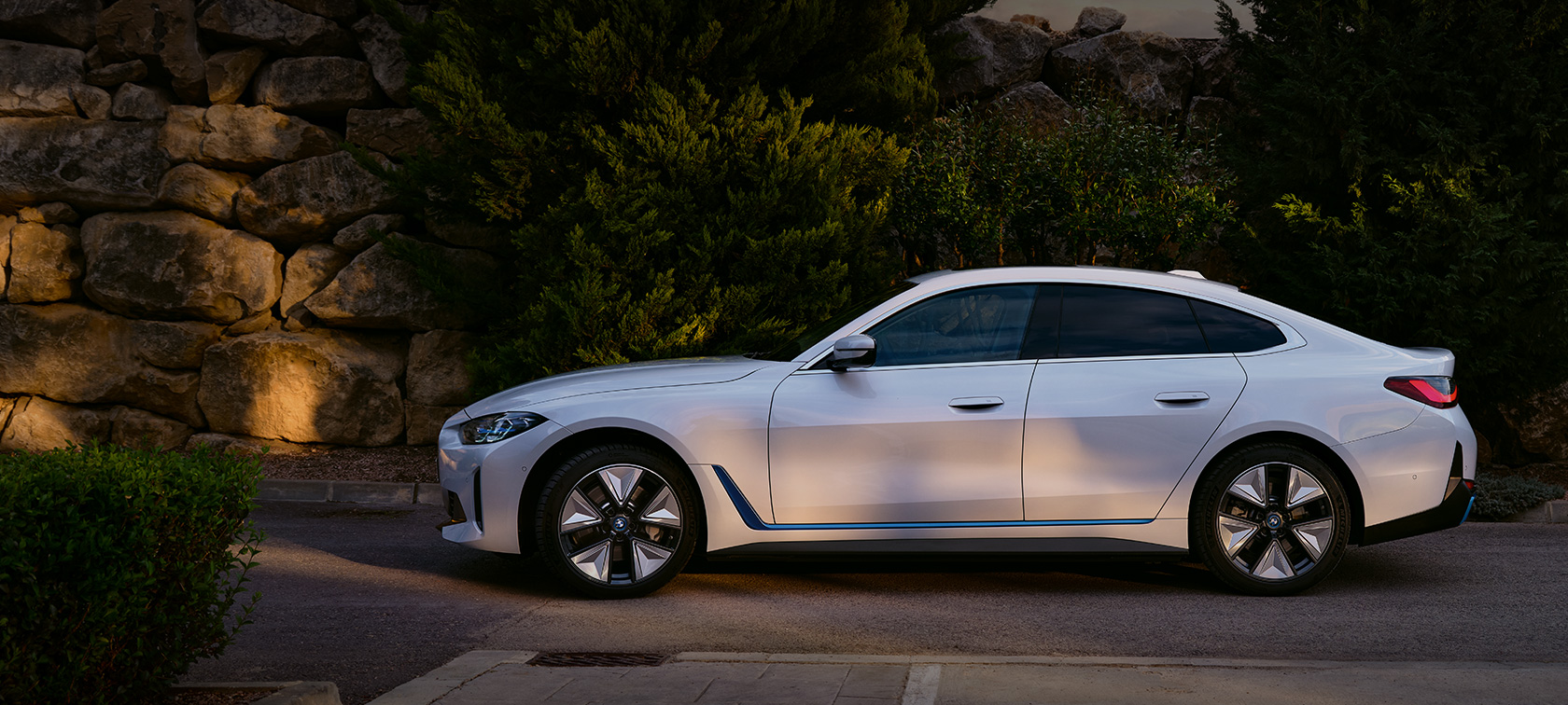 BMW i4 eDrive40 G26 2021 Mineral White three-quarter front view standing in front of lake with hill in background