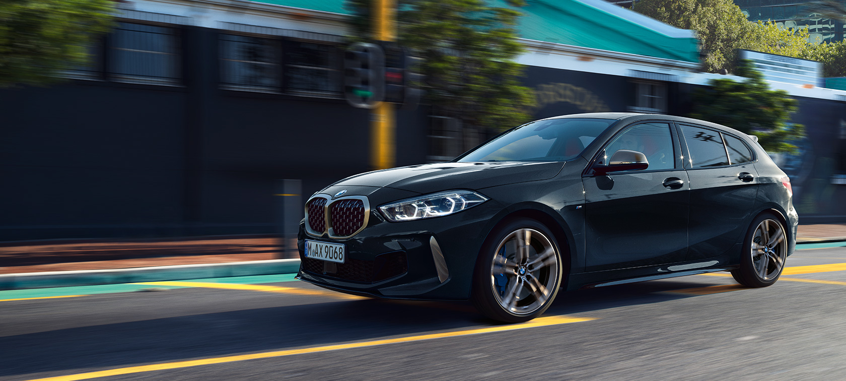The all-new BMW M135i xDrive The all-new BMW M135i xDrive in Black Sapphire metallic, three-quarter side view driving.