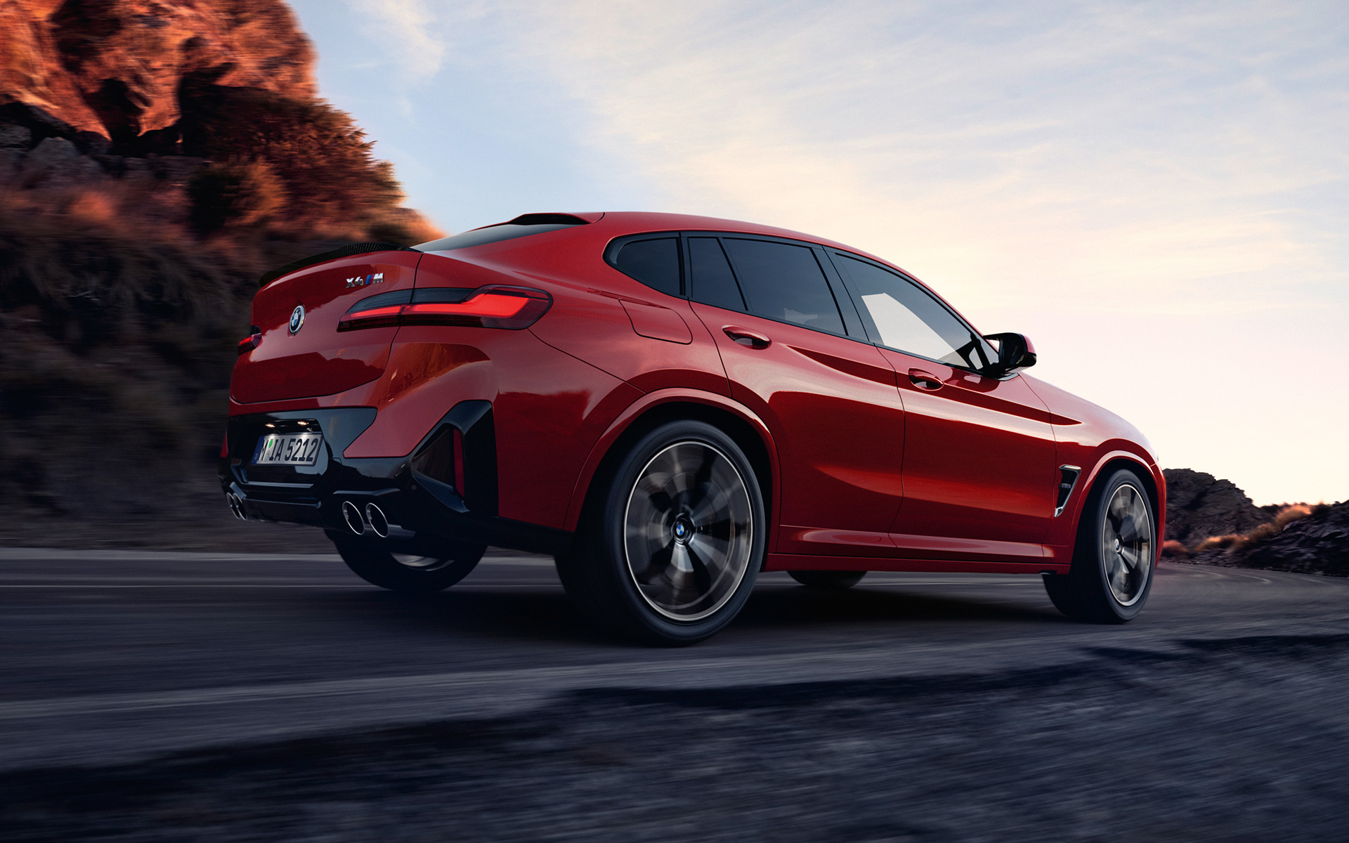BMW X4 M F98 LCI Facelift 2021 Toronto Red metallic three-quarter rear view driving on the road