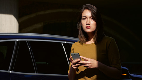 BMW ConnectedDrive overview BMW ConnectedDrive digital services overview woman with smartphone in front of BMW