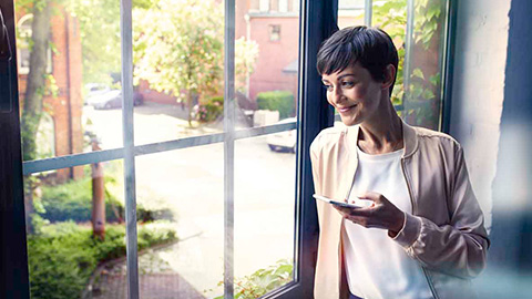 BMW ConnectedDrive FAQ  BMW ConnectedDrive FAQ frequently asked questions woman with smartphone at the window