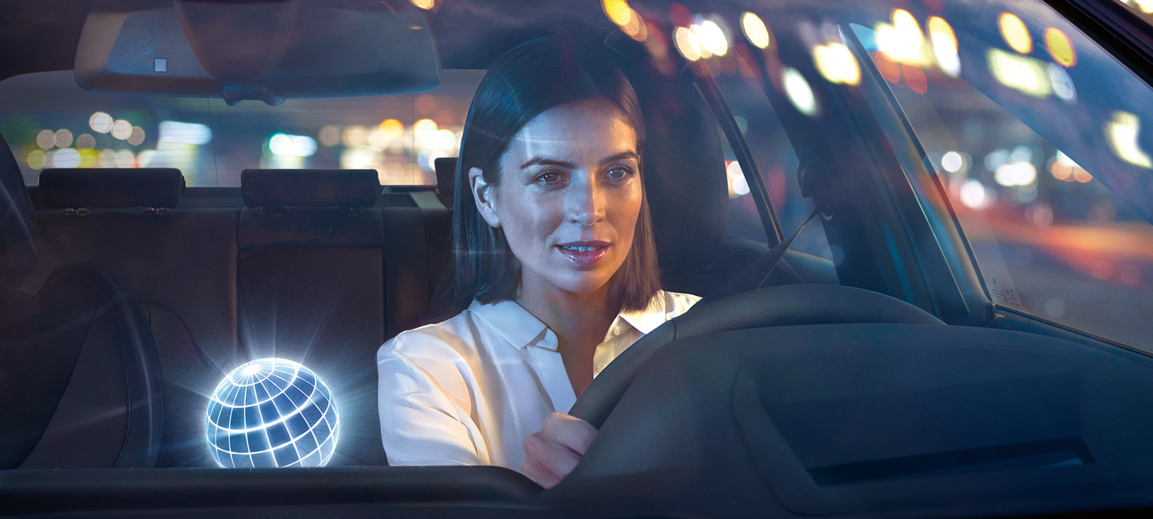 BMW Intelligent Personal Assistant Woman driving in BMW in nocturnal setting