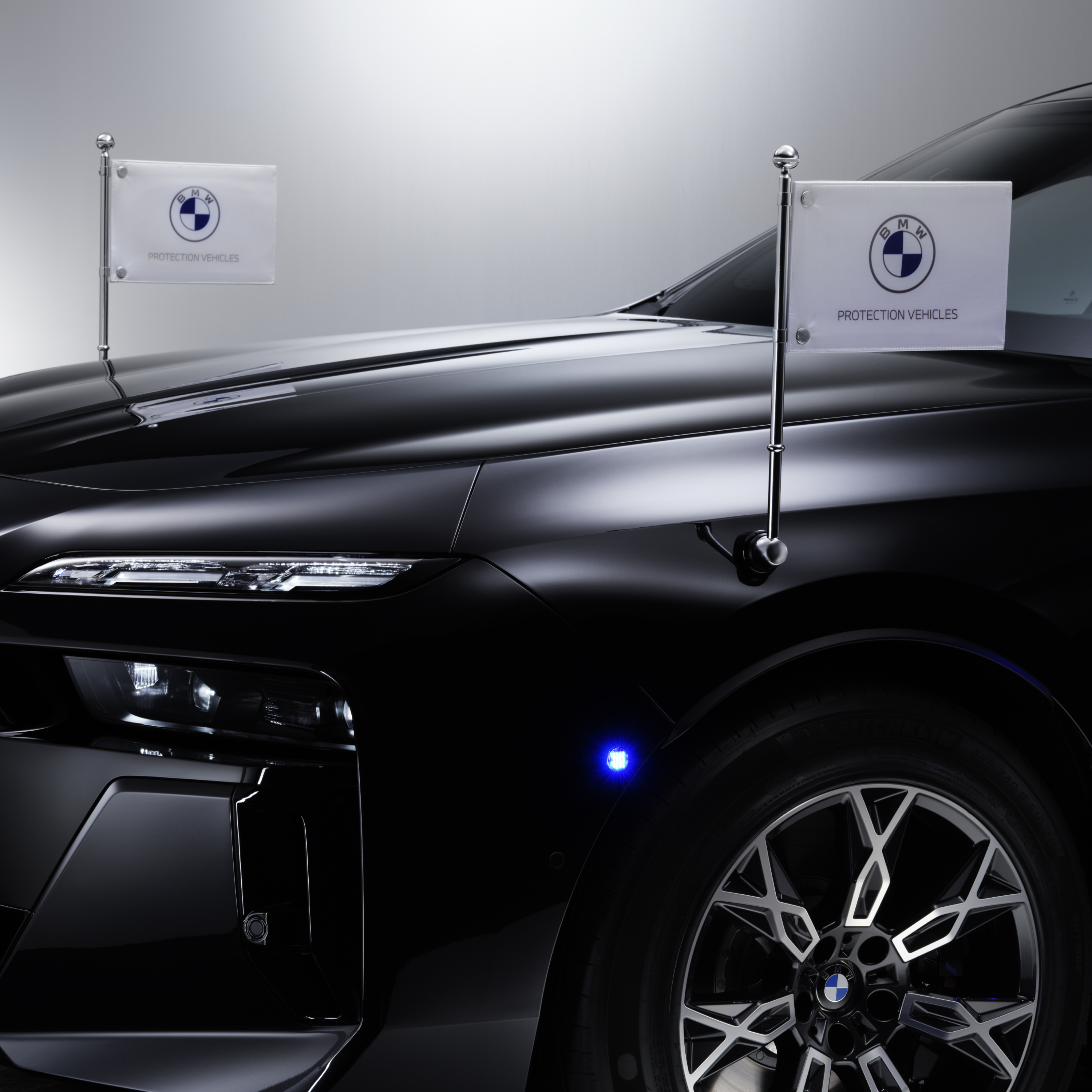 A BMW with close-up of two pennant holders at the front